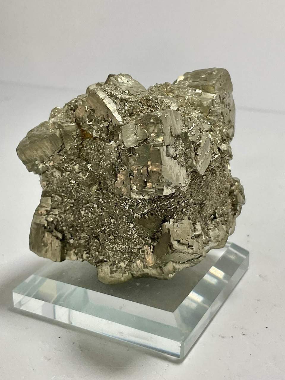 Metallic crystal cluster displayed on a clear acrylic stand