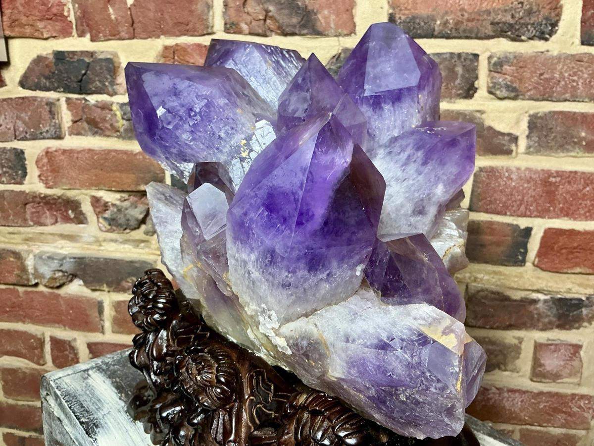 Purple amethyst crystal points on a decorative stand
