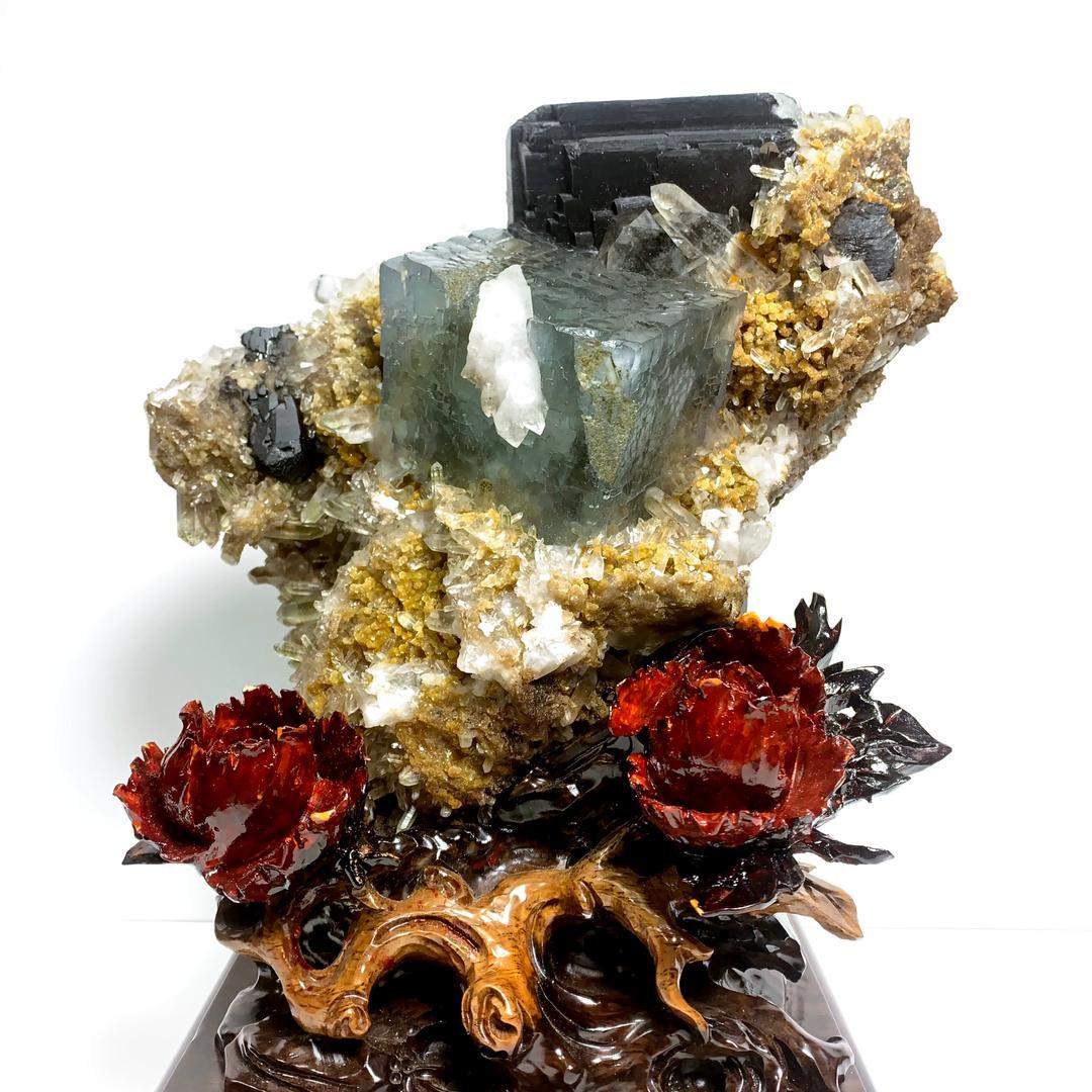 Multicoloured mineral specimen with dark crystals and red formations