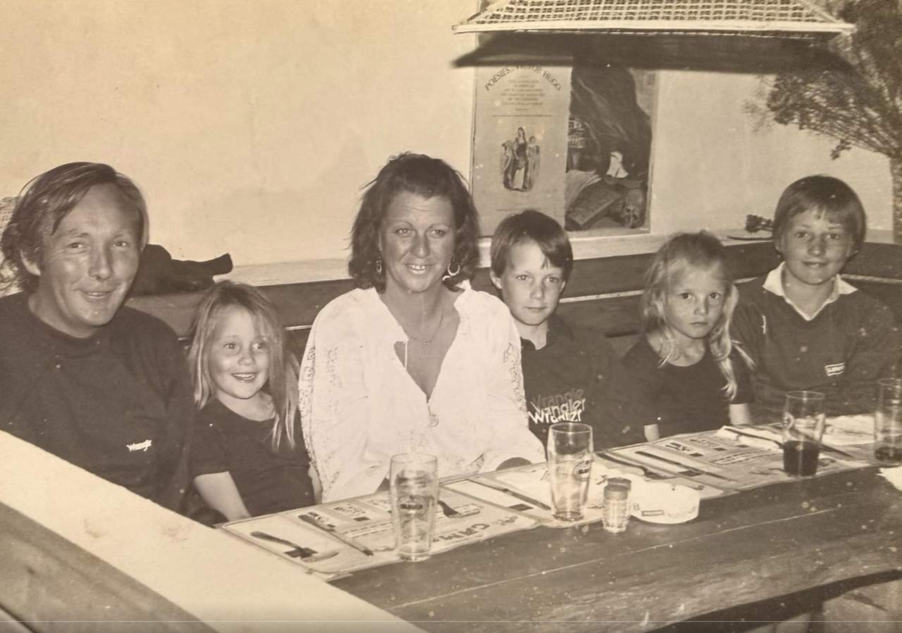 A family gathering around a table in an old photograph