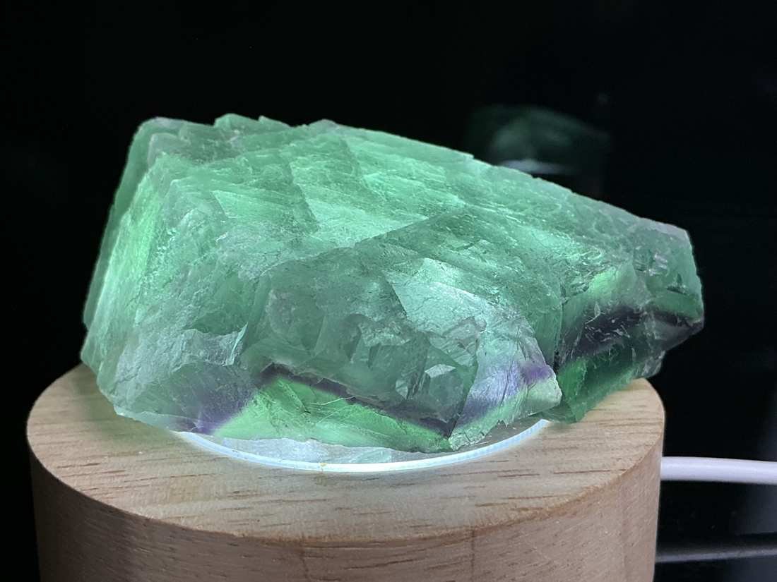 Green and purple stepped Fluorite specimen from Zhejiang, China on illuminated wooden base
