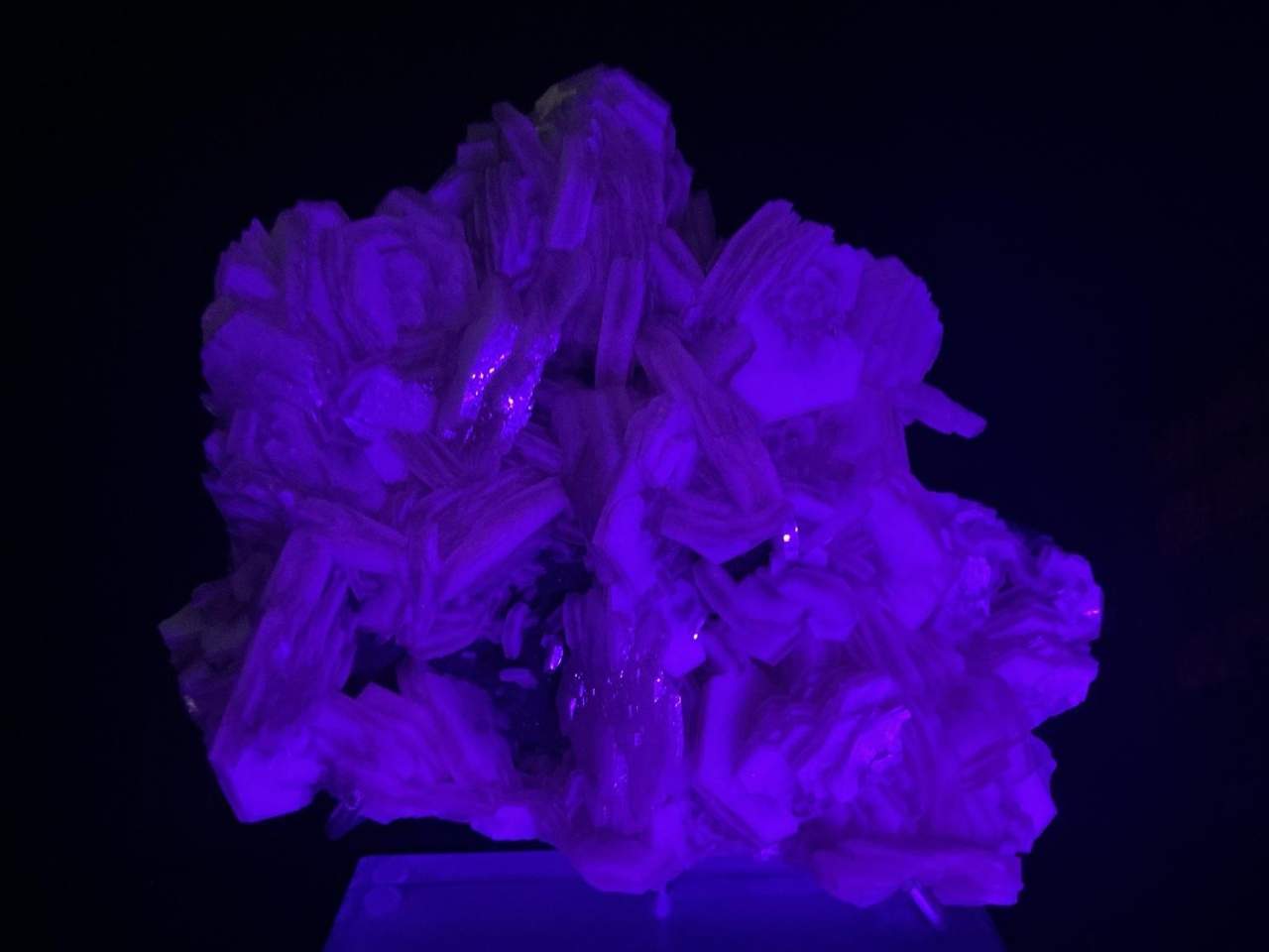 Calcite cluster fluorescing pink to purple under ultraviolet light