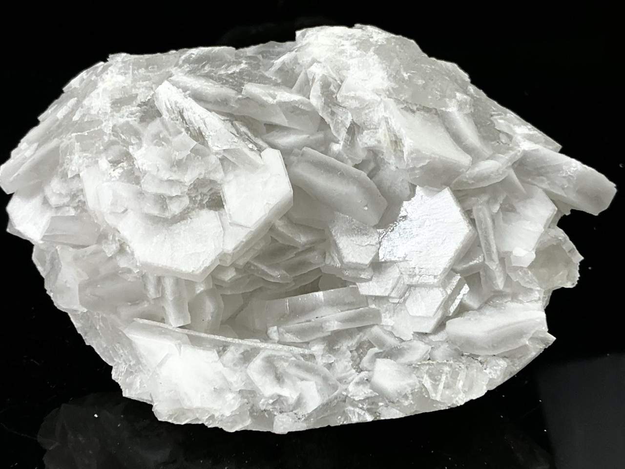 White tabular poker chip calcite crystals surrounding an open central recess on limestone matrix from Liancheng, China.